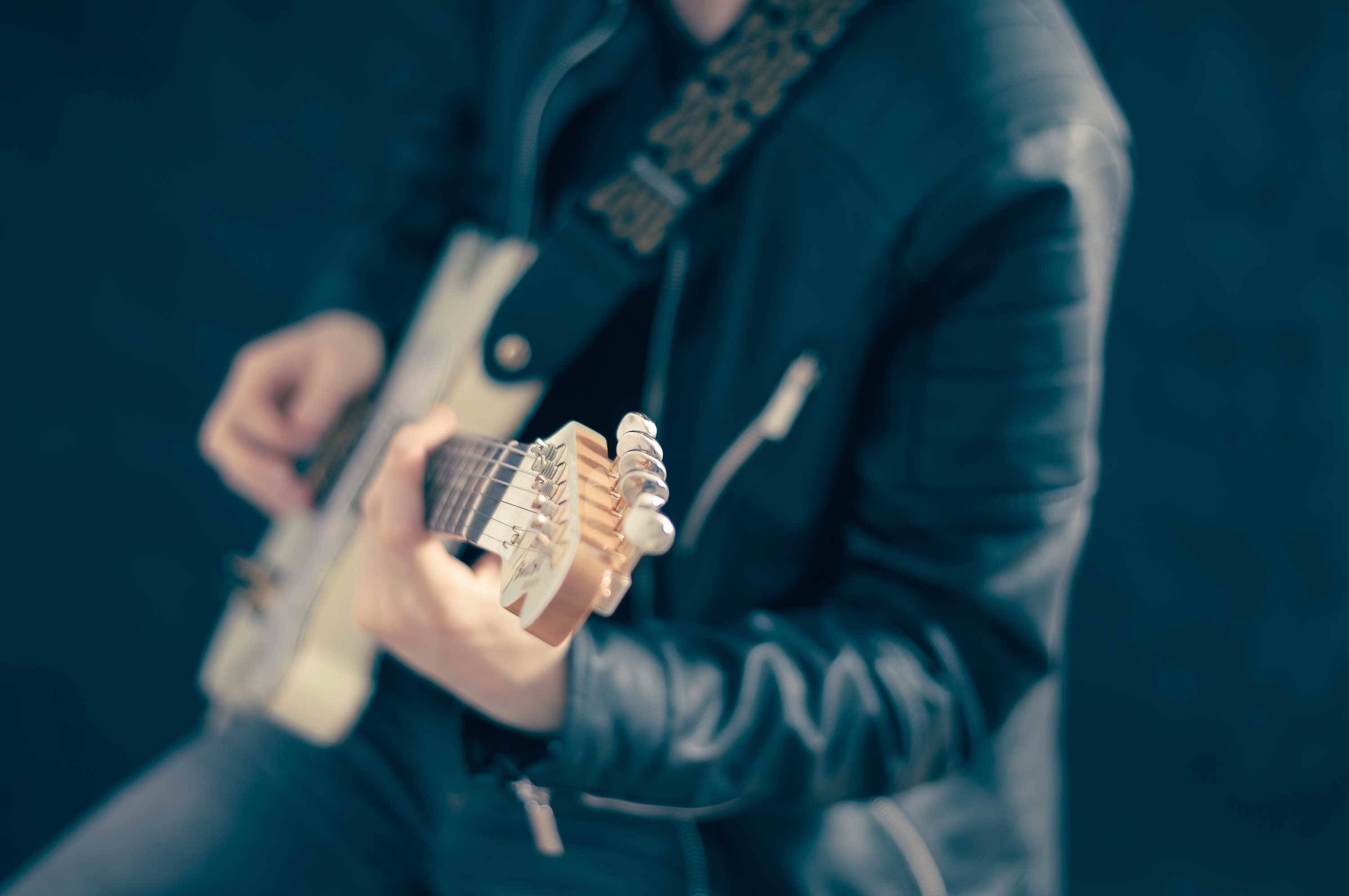 Mann mit Gitarre ist auf dem Bild zu sehen.